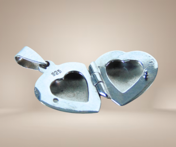 Klein gegraveerd zilveren hart medaillon locker beige achtergrond