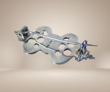 Kleine antiek zilveren bijbelslot broche sierlijk beige achtergrond