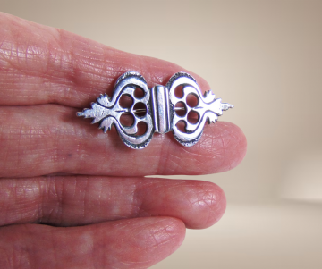 Kleine antiek zilveren bijbelslot broche sierlijk beige achtergrond 4