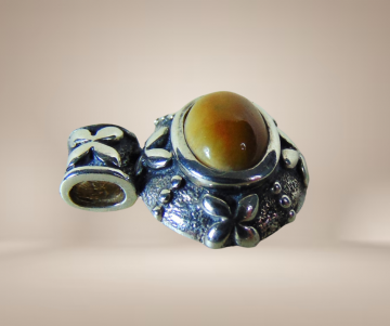 Kleine zilveren ovale thai hanger met bloempjes bruingele jade beige achtergrond 1