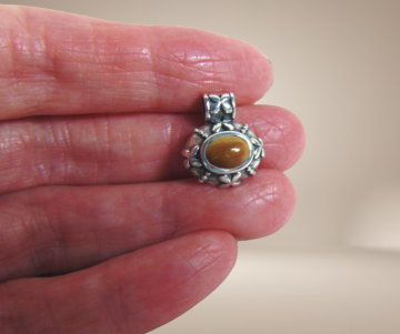 Kleine zilveren ovale thai hanger met bloempjes bruingele jade beige achtergrond 4