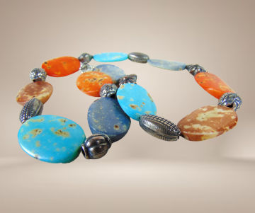 Kleurrijke ovale edelsteen verzilverde tussenkraal ketting ethnisch beige achtergrond