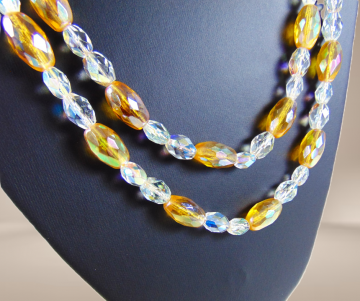 Lange dubbele 2 strengen aurora borealis ovale amber kleur kristal beige achtergrond