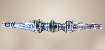 Lange dubbele zilveren breidoppen broche antiek  beige achtergrond