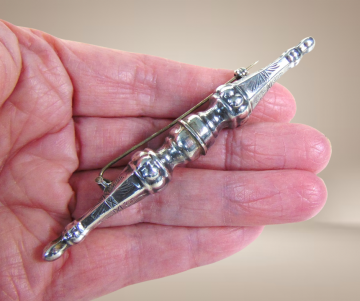 Lange dubbele zilveren breidoppen broche antiek  beige achtergrond 4