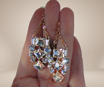 Lange high end goudkleur strass oorbellen classy beige achtergrond 3