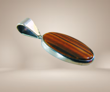 Lange ovale zilveren hanger tijgeroog beige achtergrond 1