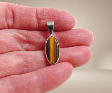 Lange ovale zilveren hanger tijgeroog beige achtergrond 3