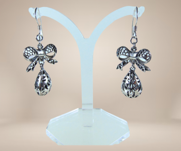 Lange zware zilveren filigraan strik druppel oorbellen beige achtergrond 1