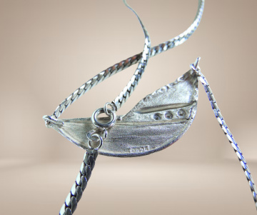 Modernist zilveren 3 diamant glad en ruig middenstuk ketting beige achtergrond