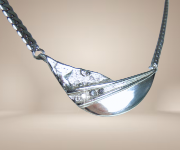 Modernist zilveren 3 diamant glad en ruig middenstuk ketting beige achtergrond 2