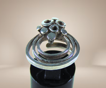 Modernist zilveren grote cirkels en bekertjesmos design ring beige achtergrond 2