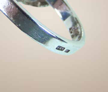 Modernist zilveren grote cirkels en bekertjesmos design ring beige achtergrond 3