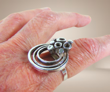 Modernist zilveren grote cirkels en bekertjesmos design ring beige achtergrond 4