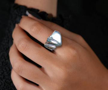 Modernistische asym zilveren ring op hand