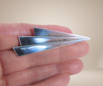 Modernistische flits vliegtuigje broche beige achtergrond 4