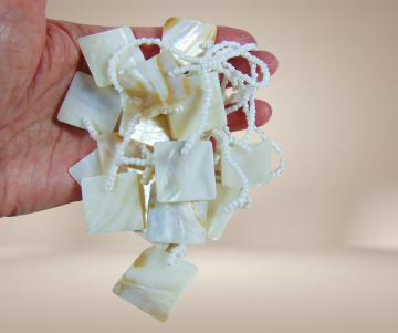 Mop parelmoer vierkanten speelse witte ketting beige achtergrond 3