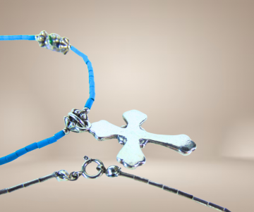 Native stijl liquid zilver ketting tuquoise pijpjes en kruis hanger beige achtergrond