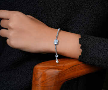 Nicole preziosi arezzo huisjes zilveren armband op arm hout stoel