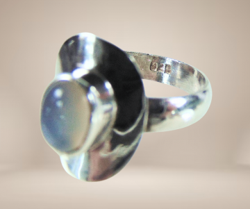 Nieuwe zilveren ring ovaal maansteen beige achtergrond