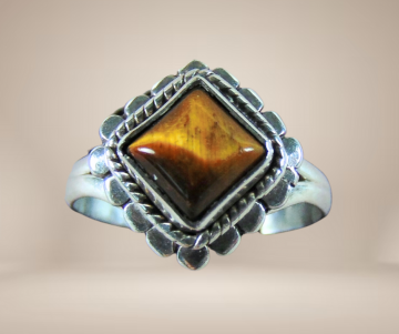 Nieuwe zilveren ring vierkante tijgeroog beige achtergrond