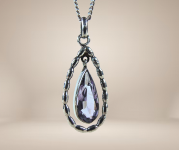 Ovale druppel amethist zilveren hanger ketting beige achtergrond