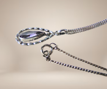 Ovale druppel amethist zilveren hanger ketting beige achtergrond 2