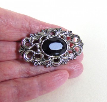 Ovale verzilverde opengewerkte broche dieppaarsrode glassteen 1