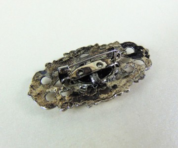 Ovale verzilverde opengewerkte broche dieppaarsrode glassteen 6