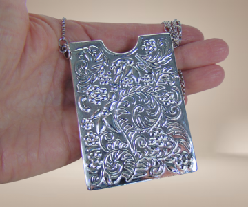 Reo zilveren repousse kaarthouder hanger ketting beige achtergrond 2