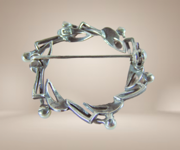 Ronde art deco zilveren broche met parels beige achtergrond 2