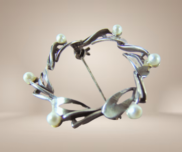 Ronde art deco zilveren broche met parels beige achtergrond 3