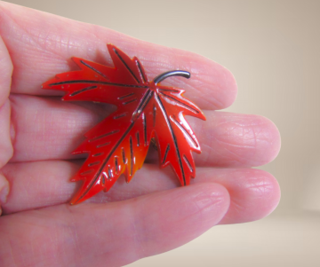 Rood email blad broche beige achtergrond 4