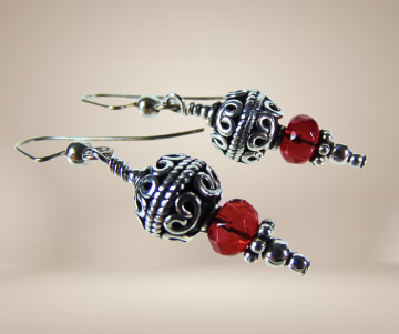 Sardijnse zilveren oorbellen rode glaskraal beige achtergrond