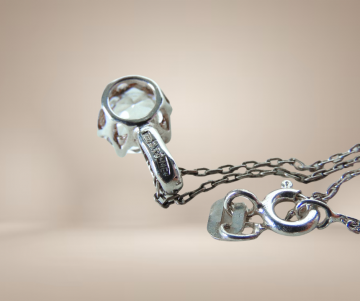 Solitair bergkristal hanger me rond ketting beige achtergrond