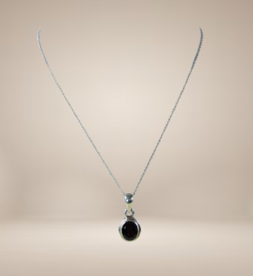 Strak zilveren ovale granaat hanger aan ketting beige achtergrond 2