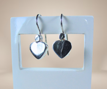 Strakke gladde hart oorbellen beige achtergrond