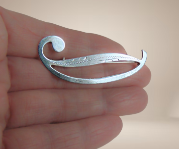 Strakke modernist  am zilver slee krul broche gravure beige achtergrond 3