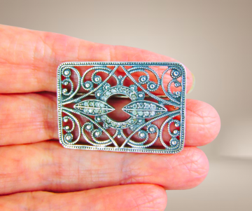 Timeless nieuwe zilveren rechthoekige opengewerkte broche art deco kristal beige achtergrond