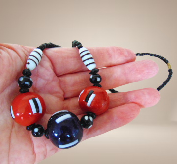 Vintage zwart rood blauwe grote streepjes glass kralen handgemaakt beige achtergrond