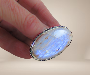 Vuur maansteen ovale zilveren broche beige achtergrond 3