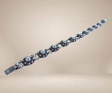 Zeeuwse knoop knop zilveren armband antiek beige achtergrond