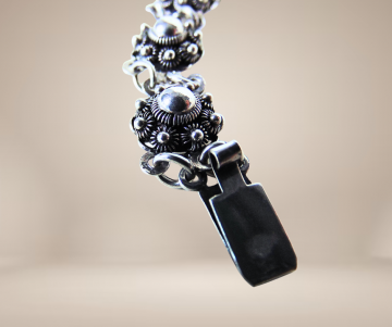 Zeeuwse knoop knop zilveren armband antiek beige achtergrond 2