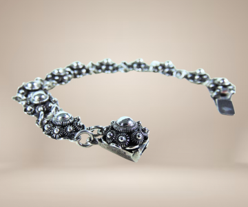 Zeeuwse knoop knop zilveren armband antiek beige achtergrond 3