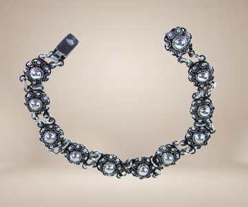 Zeeuwse knoop knop zilveren armband antiek beige achtergrond 4