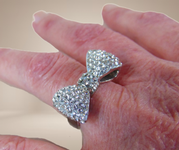 Zilver kleur strik bling ring strass beige achtergrond