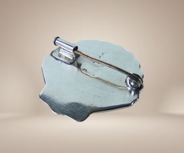 Zilveren abalone schelp broche beige achtergrond