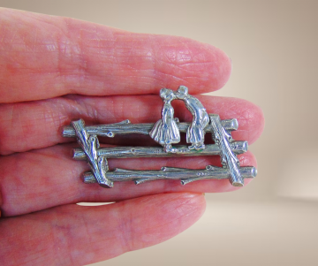 Zilveren broche boeren kinderen kussen op hek beige achtergrond 3