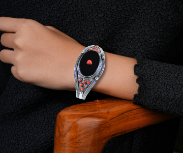 Zilveren cuff onyx koraal breed op arm hout stoel