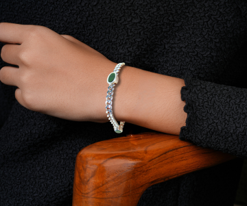 Zilveren gourmet schakel armband 3 groen jade inleg op arm hout stoel